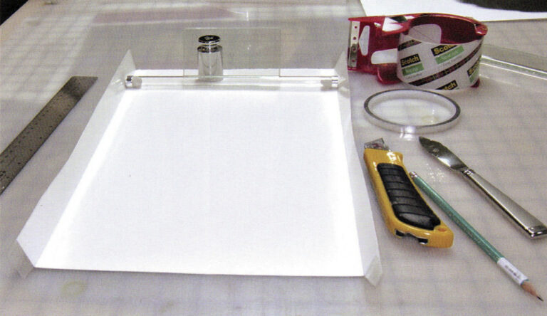 image showing a workspace for coating photographic paper including the paper and various tools
