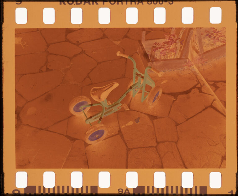 Picture of a color negative film strip depicting a children tricycle